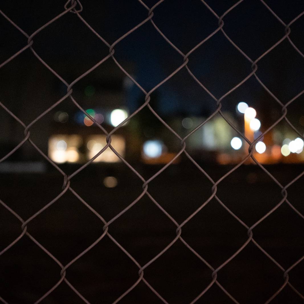 grey metal fence during night time